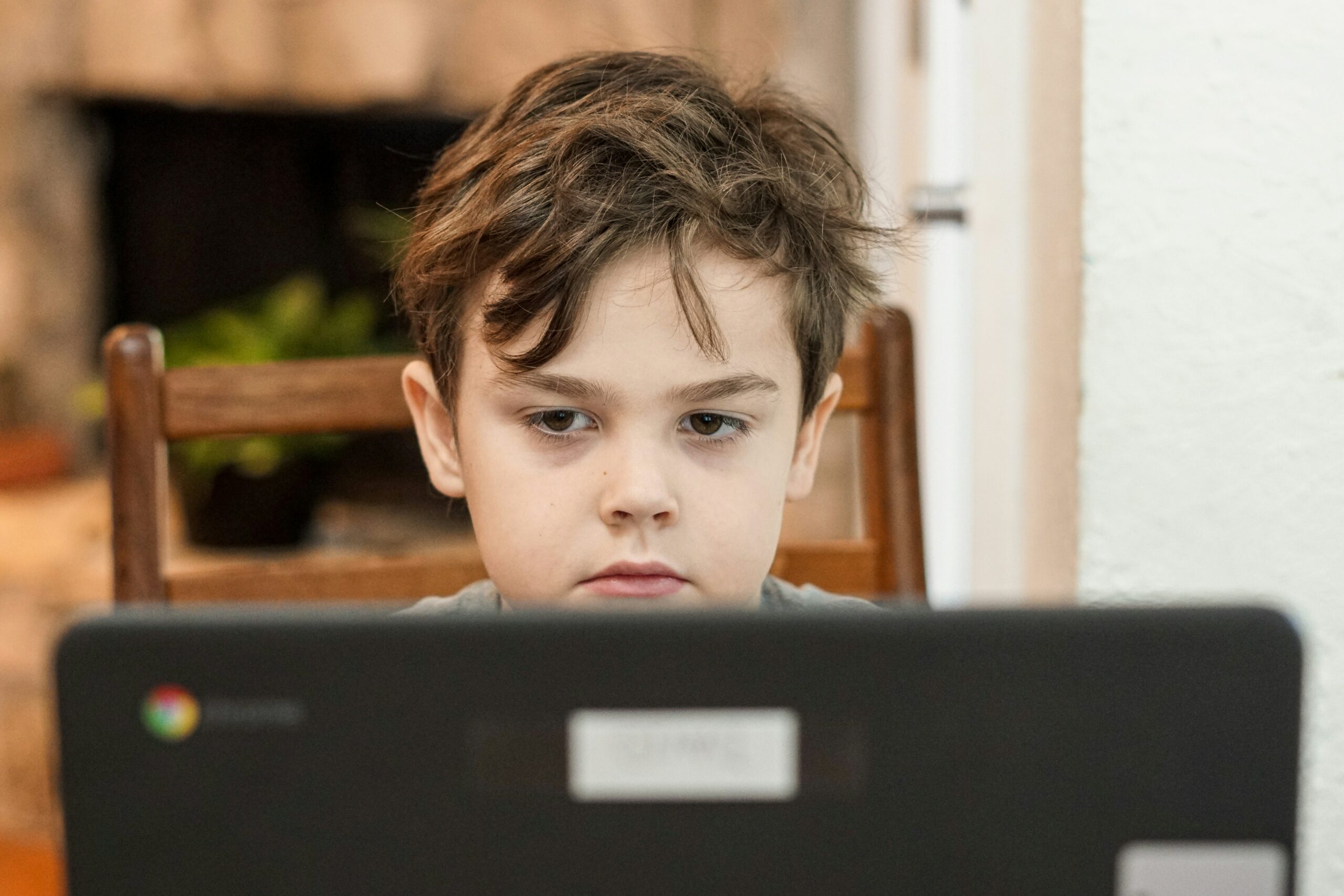 student looking using some tools for vitual classrooms on a laptop computer while participating in distance home learning